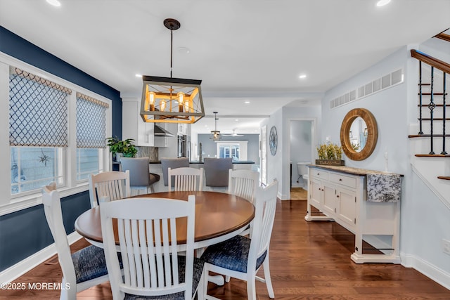 dining area with dark hardwood / wood-style floors and a notable chandelier