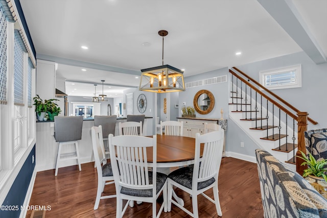 dining room with dark wood-type flooring and a chandelier