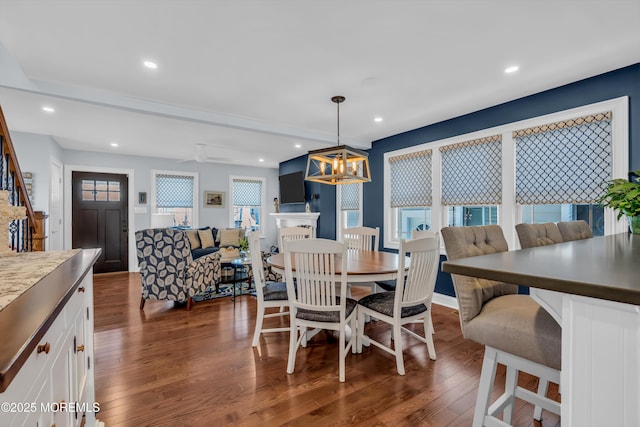 dining room featuring dark hardwood / wood-style floors and ceiling fan with notable chandelier