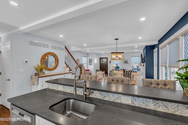 kitchen featuring hardwood / wood-style floors, pendant lighting, sink, and stainless steel dishwasher