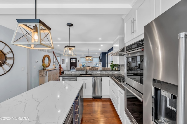 kitchen with white cabinetry, appliances with stainless steel finishes, decorative light fixtures, and kitchen peninsula