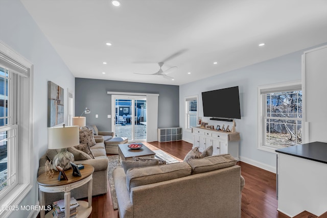 living room featuring dark wood-type flooring and ceiling fan