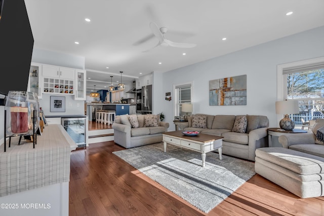 living room featuring ceiling fan and dark hardwood / wood-style floors