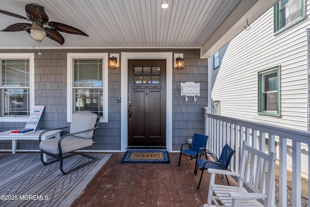 view of exterior entry featuring covered porch and ceiling fan