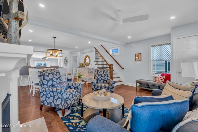 living room featuring hardwood / wood-style flooring, ceiling fan, and beamed ceiling