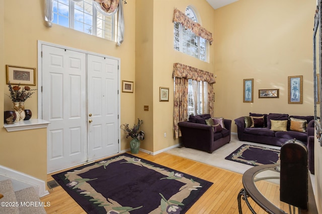 foyer entrance with hardwood / wood-style flooring and a towering ceiling