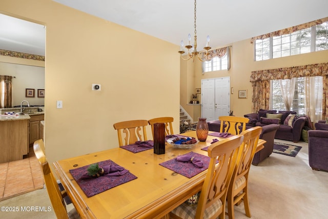 carpeted dining space featuring an inviting chandelier and a towering ceiling