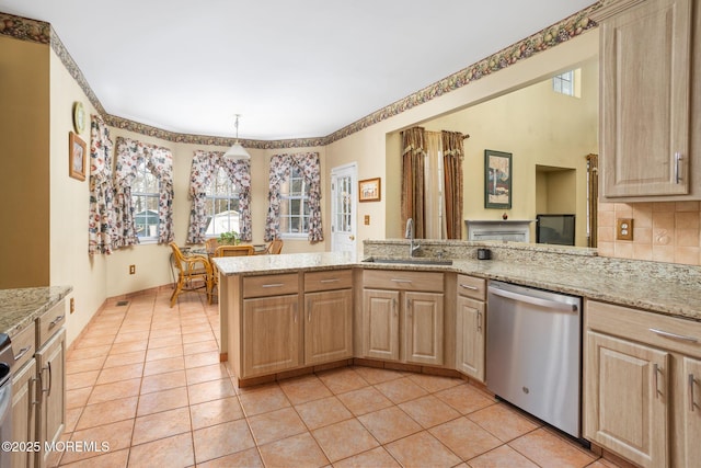 kitchen with stainless steel dishwasher, light brown cabinetry, and kitchen peninsula