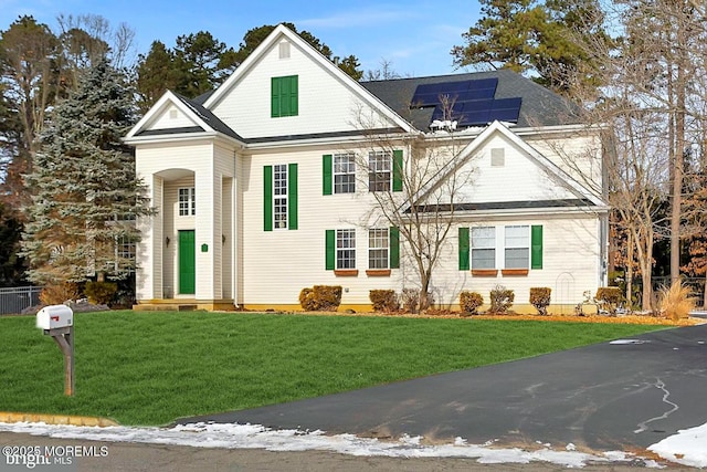 view of front property with a front lawn and solar panels