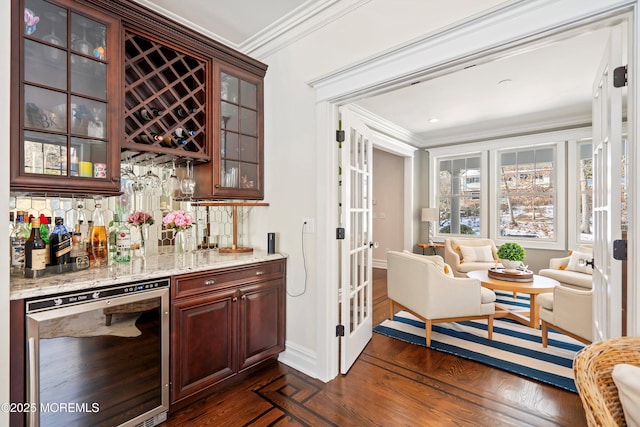 bar with crown molding, dark hardwood / wood-style floors, light stone counters, tasteful backsplash, and beverage cooler