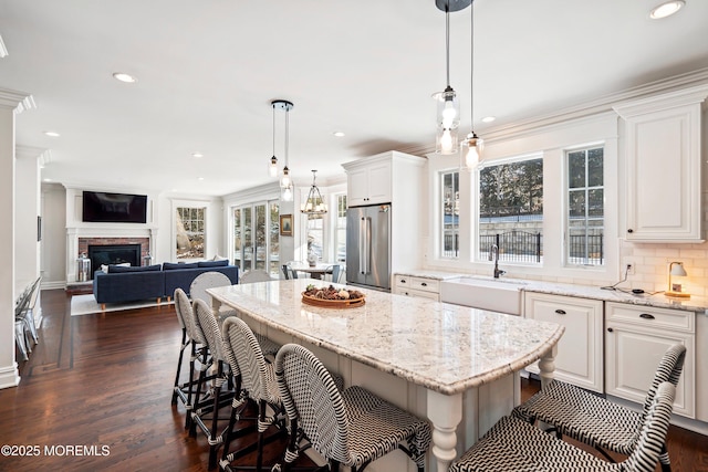 kitchen with high quality fridge, white cabinets, and a kitchen island