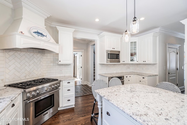 kitchen featuring pendant lighting, a breakfast bar area, stainless steel appliances, and white cabinets