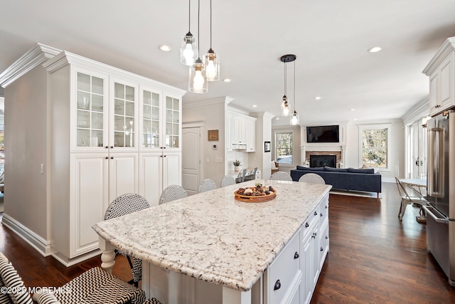 kitchen featuring high quality fridge, a center island, a breakfast bar area, and white cabinets