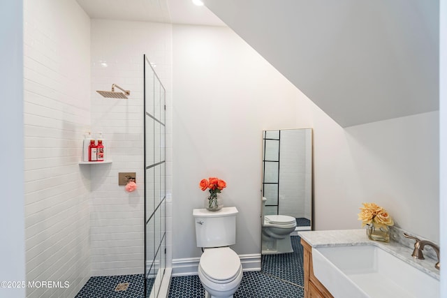 bathroom with vanity, toilet, and a tile shower