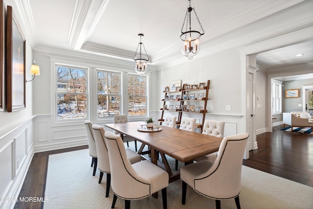 dining space with crown molding, dark hardwood / wood-style floors, and a raised ceiling