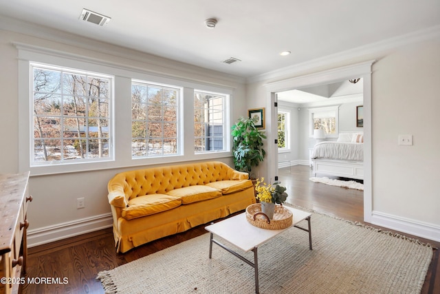 living area featuring ornamental molding and dark hardwood / wood-style flooring