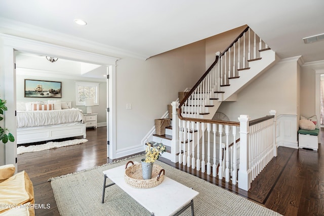 stairs featuring ornamental molding and wood-type flooring