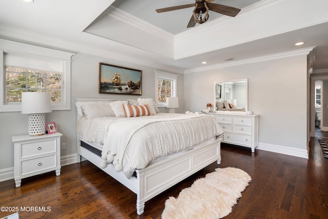 bedroom with ceiling fan, a tray ceiling, dark hardwood / wood-style floors, and multiple windows