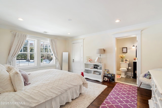 bedroom featuring crown molding, ensuite bath, and dark wood-type flooring