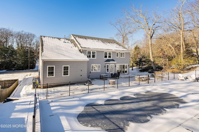 view of snow covered back of property