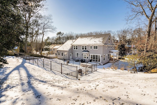 view of snow covered back of property