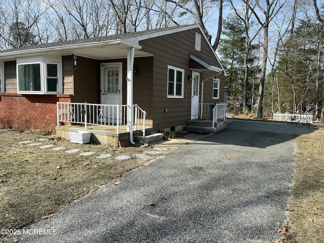 view of front of house with brick siding, covered porch, and driveway