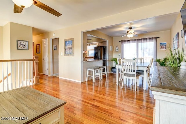 dining space with ceiling fan and light hardwood / wood-style floors