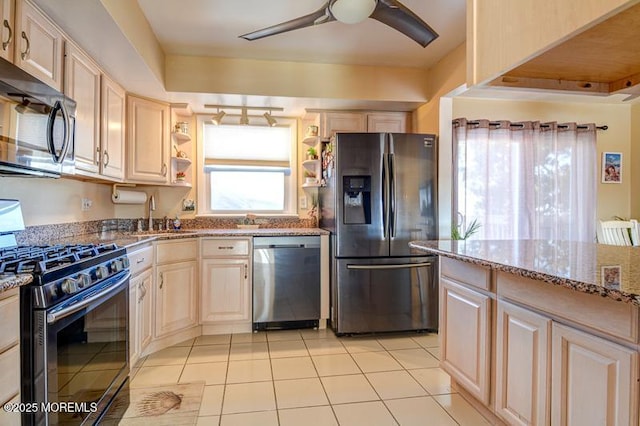 kitchen featuring sink, light tile patterned floors, ceiling fan, stone counters, and stainless steel appliances