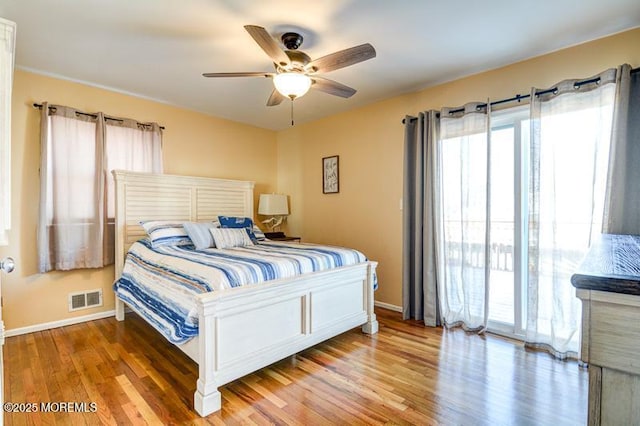 bedroom with hardwood / wood-style floors, access to exterior, and ceiling fan