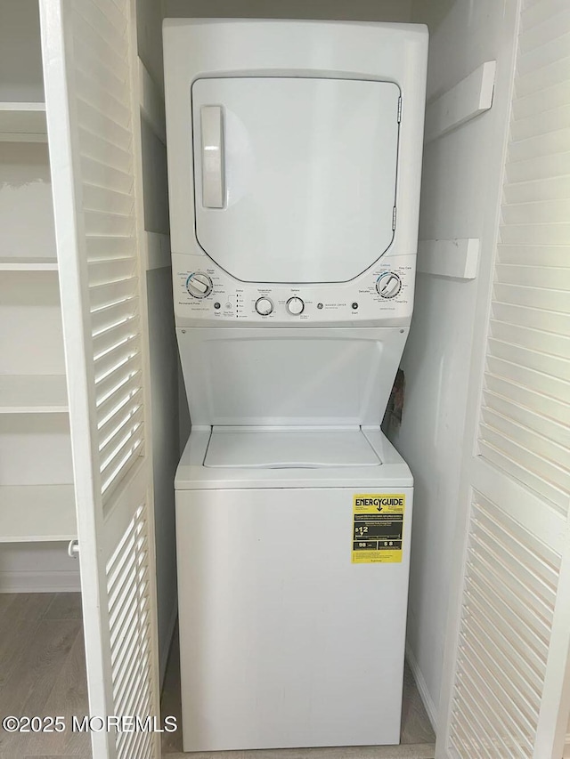 clothes washing area featuring stacked washer / dryer