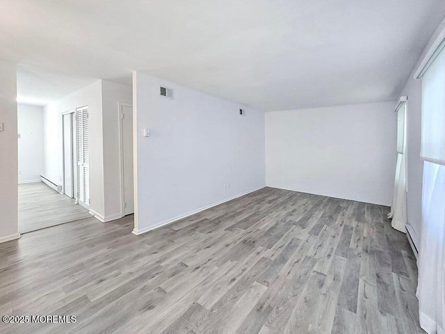 19B Plaza Del Campillo Unit 1000, Freehold, NJ 07728 - spare room featuring baseboard heating and light wood finished floors