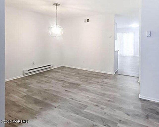 19B Plaza Del Campillo Unit 1000, Freehold, NJ 07728 - unfurnished dining area with a baseboard heating unit and wood finished floors