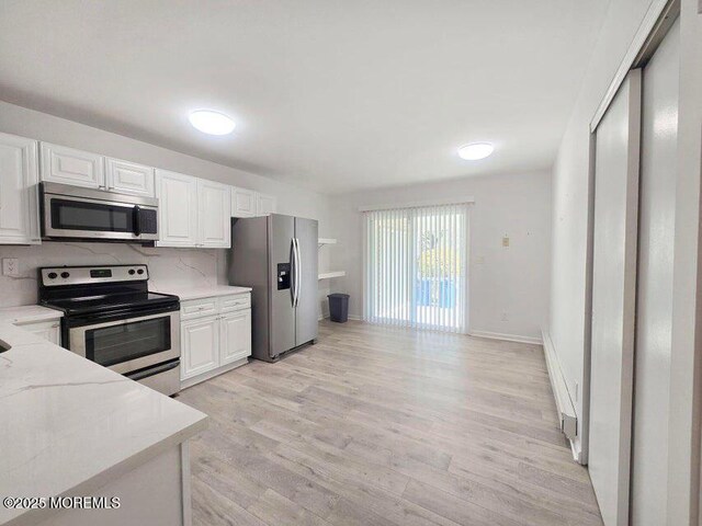 19B Plaza Del Campillo Unit 1000, Freehold, NJ 07728 - kitchen featuring stainless steel appliances, white cabinets, light wood-style floors, and a baseboard radiator