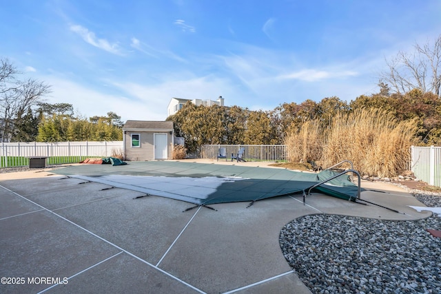 view of swimming pool with a patio and a storage unit