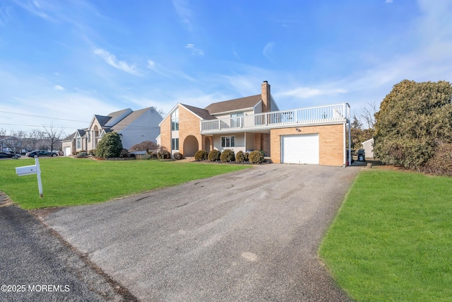 view of front of property featuring a garage, a front lawn, and a balcony