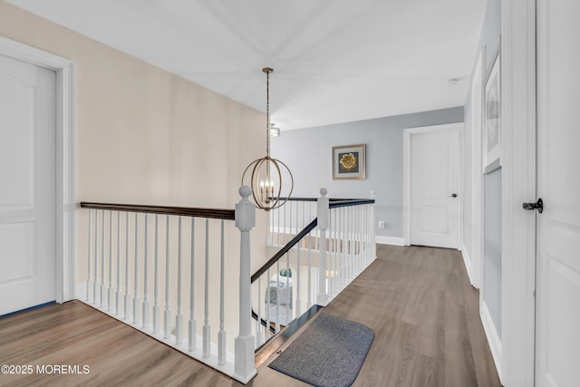 hallway with hardwood / wood-style flooring and a notable chandelier