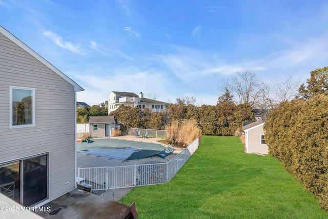 view of yard with a storage shed, a covered pool, and a patio area