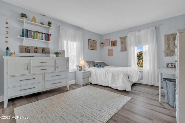 bedroom with multiple windows and hardwood / wood-style flooring