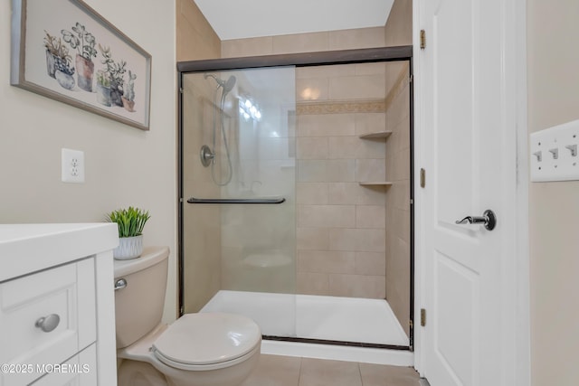 bathroom with vanity, toilet, a shower with shower door, and tile patterned flooring