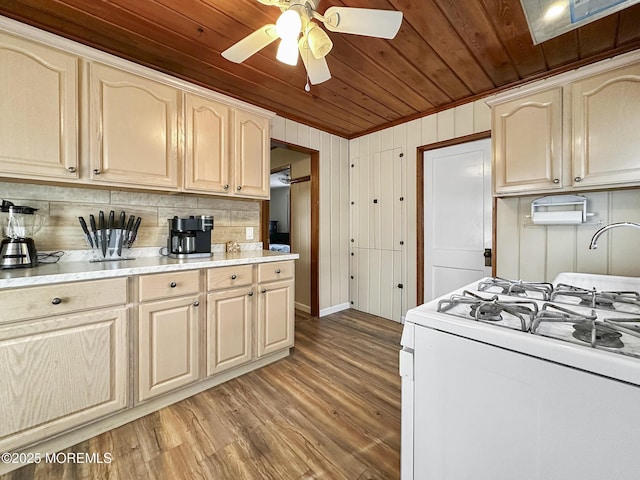 kitchen with wooden ceiling, ornamental molding, hardwood / wood-style flooring, ceiling fan, and white gas range oven