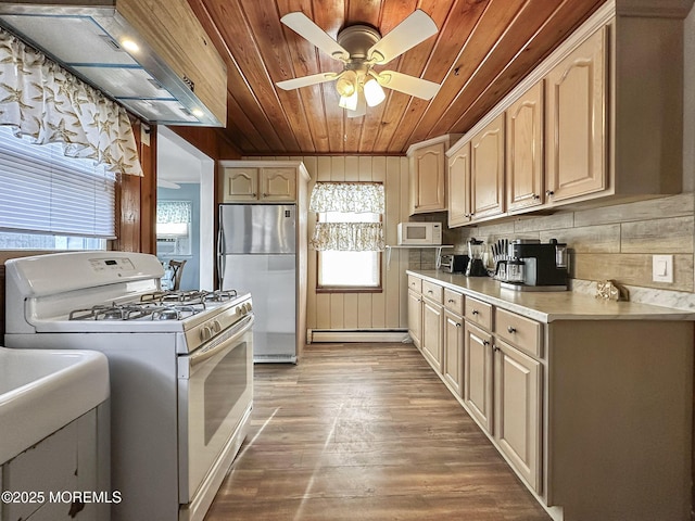 kitchen with wood ceiling, ceiling fan, hardwood / wood-style flooring, white appliances, and wall chimney range hood