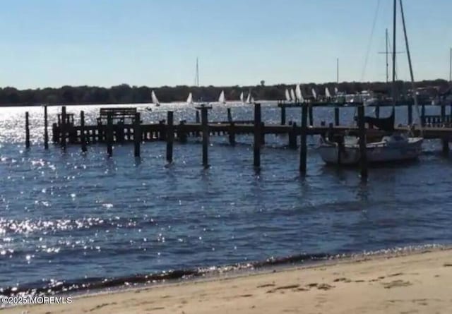 view of dock with a view of the beach and a water view