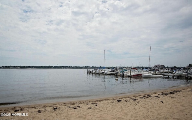 view of dock with a view of the beach and a water view