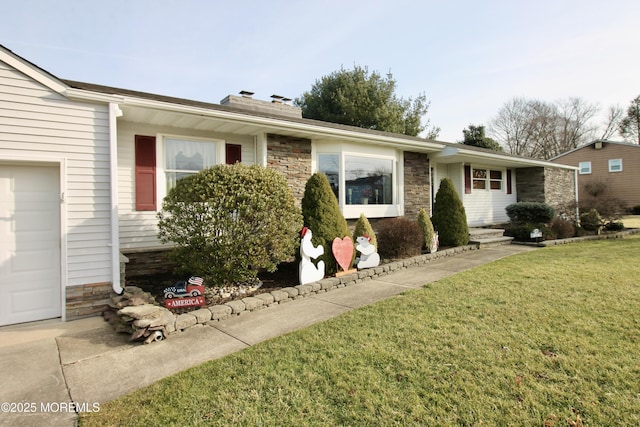 single story home featuring a garage and a front lawn