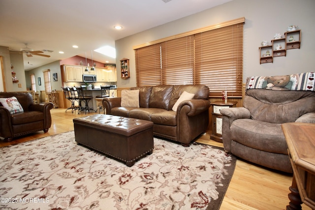 living room featuring ceiling fan and light hardwood / wood-style floors