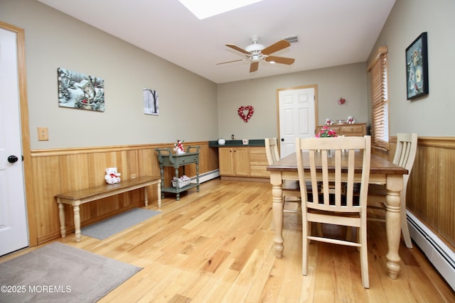 dining room featuring light hardwood / wood-style floors, ceiling fan, and baseboard heating