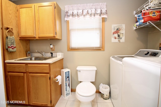 washroom featuring sink, washing machine and dryer, and light tile patterned floors