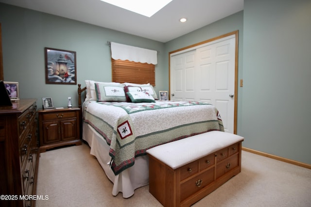 carpeted bedroom featuring a skylight and a closet