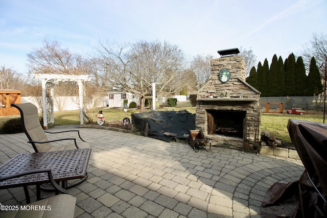 view of patio with an outdoor stone fireplace and a pergola