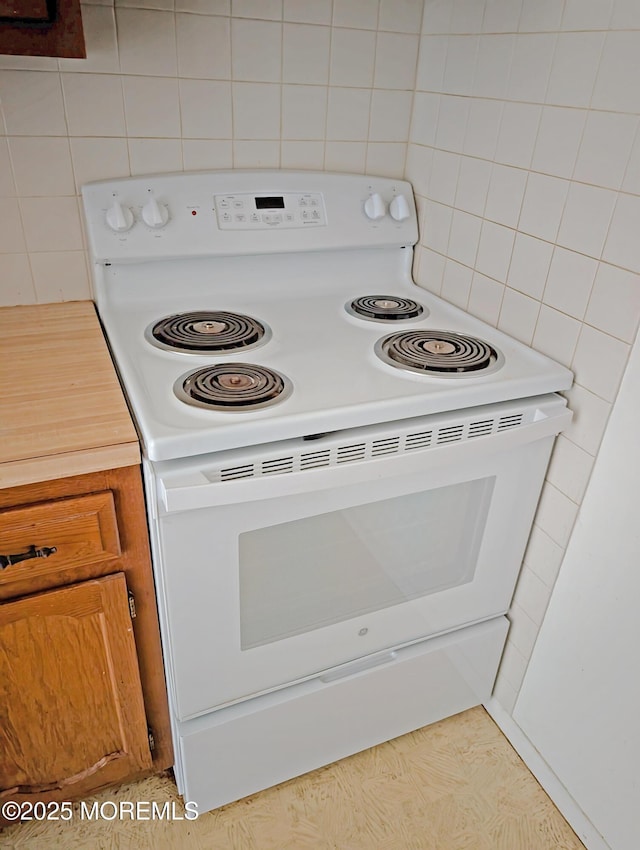 kitchen featuring electric stove and tile walls